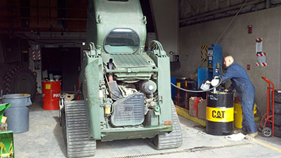 A man working on the engine of a tractor.